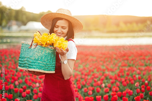 Cheerful florist smelling flowers on farm © kegfire
