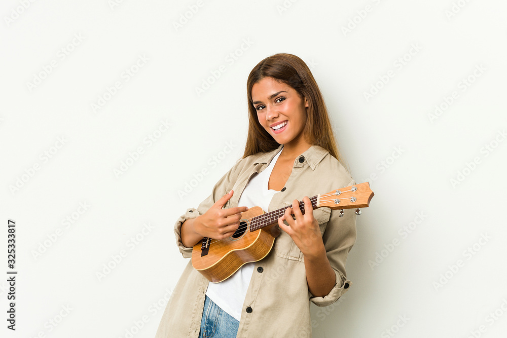 Young caucasian woman playing ukelele isolated Young caucasian woman playing ukelele isolated