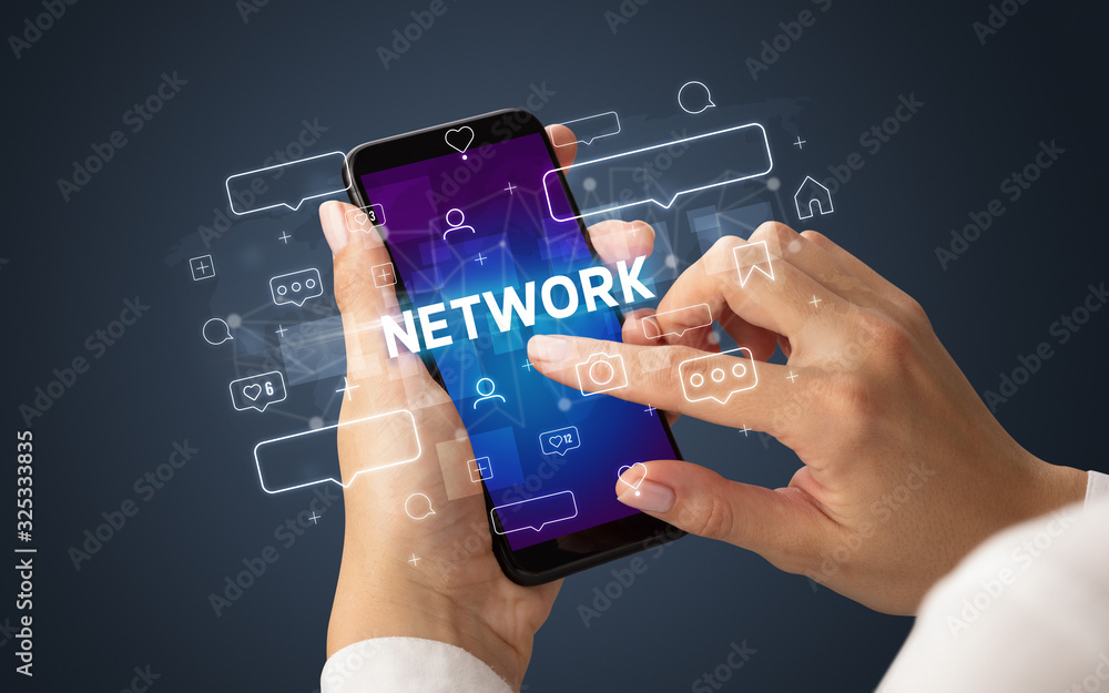 Female hand typing on smartphone with NETWORK inscription, social media concept Female hand typing on smartphone with NETWORK inscription, social media concept
