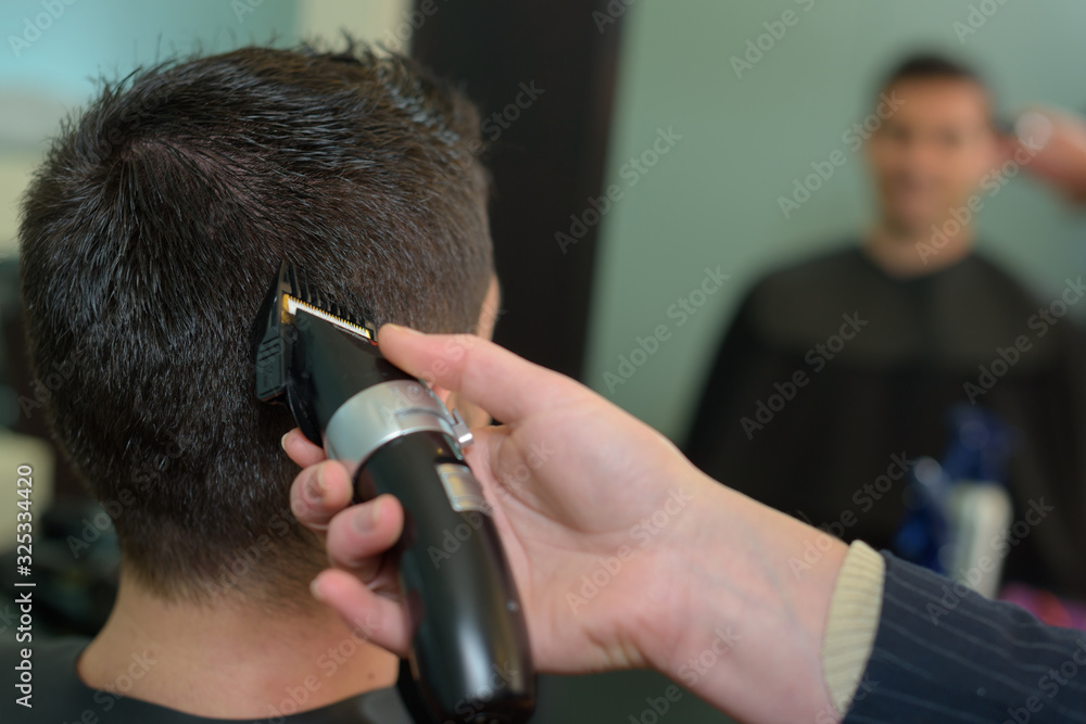 young man getting haircut by hairdresser
