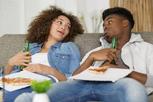 couple on a sofa ate too much pizza photo