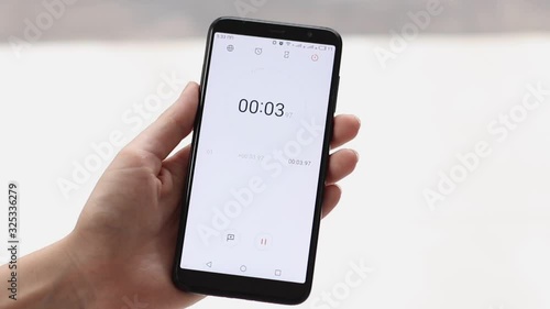 The stopwatch in the hands of a woman counts to 10 and the girl stops him
