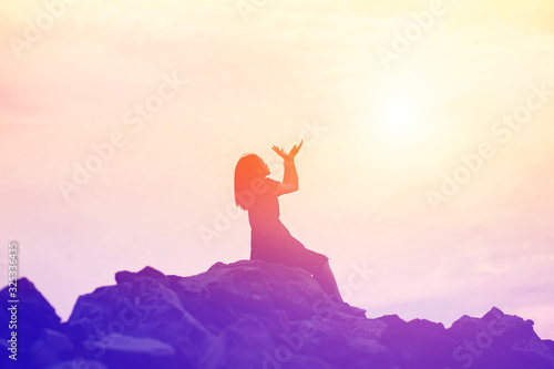 silhouette of woman praying over beautiful sky background