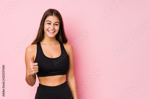 Young caucasian fitness woman doing sport isolated smiling and raising thumb up