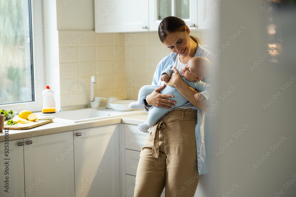Young mother resting with her kid in the kitchen Young mother resting with her kid in the kitchen