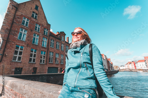Woman tourist sitting and enjoying a center of Bruges, Belgium