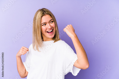 Wallpaper Mural Young blonde caucasian woman isolated raising fist after a victory, winner concept. Torontodigital.ca