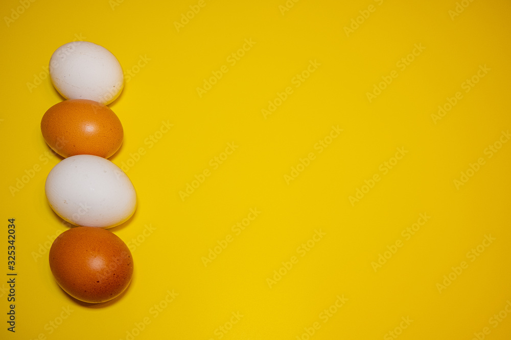 White and brown Easter eggs bright yellow background. Concept happy Easter. Minimalism concept. Top view.