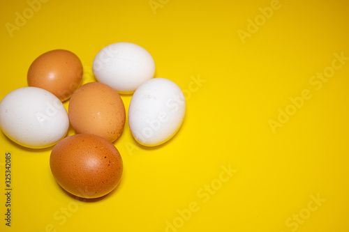 White and brown Easter eggs bright yellow background. Concept happy Easter. Minimalism concept. Top view.