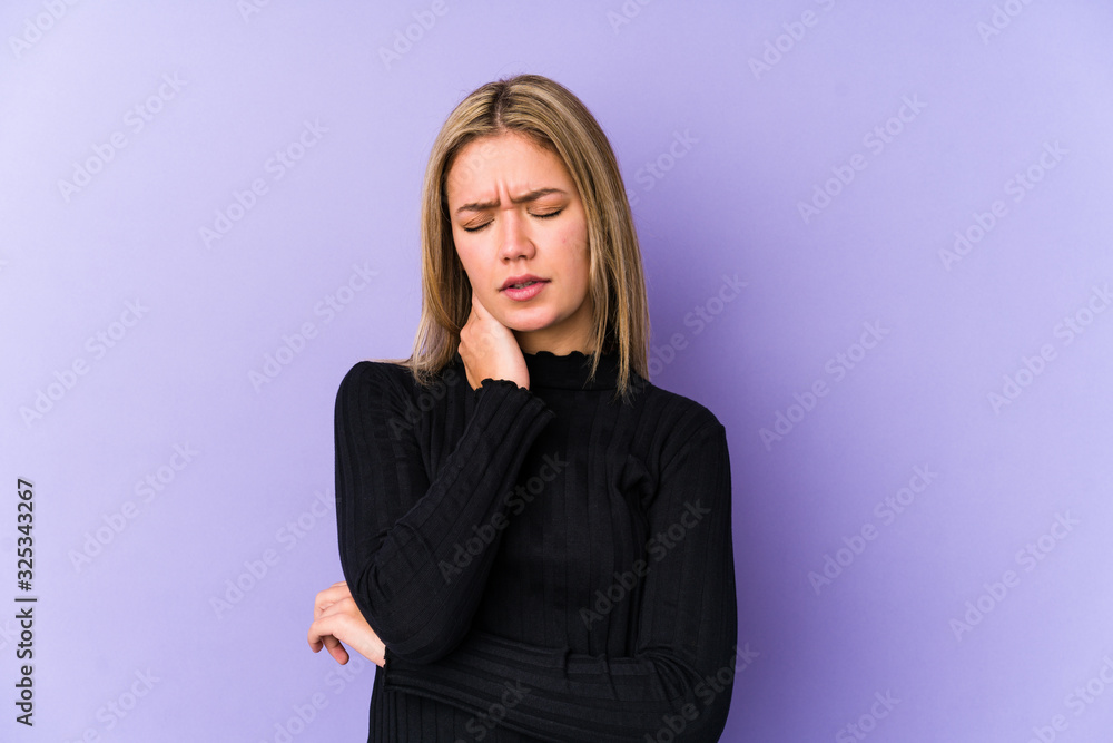 Obraz premium Young blonde caucasian woman isolated having a neck pain due to stress, massaging and touching it with hand.