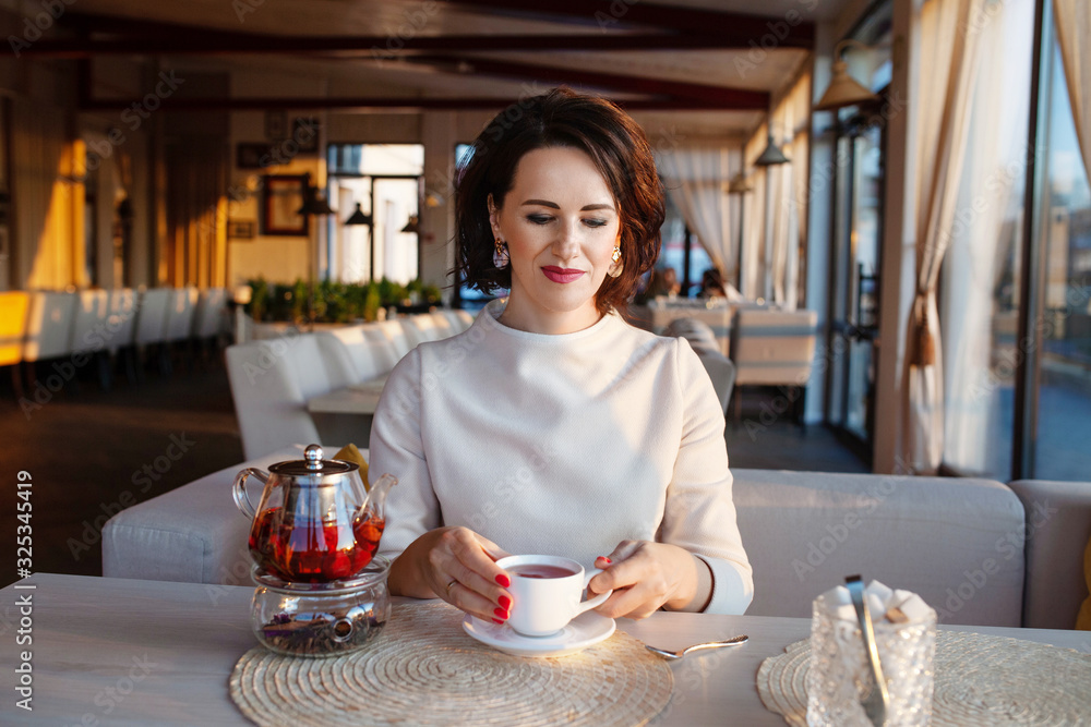 Beautiful women drinking tea at cozy cafe. Businesswomen take a break with teacup. Bright lifestyle photo in a stylish cafe. Beautiful women drinking tea at cozy cafe. Businesswomen take a break with teacup. Bright lifestyle photo in a stylish cafe.