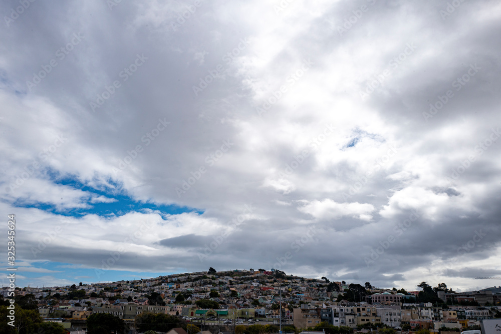 hillside of colorful houses with cool clouds overhead hillside of colorful houses with cool clouds overhead