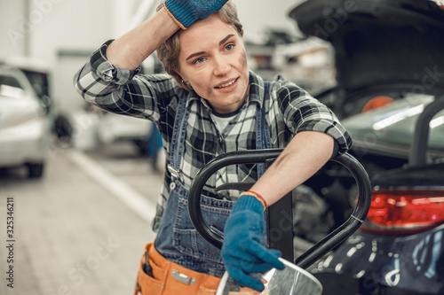 Girl in overalls standing in a garage