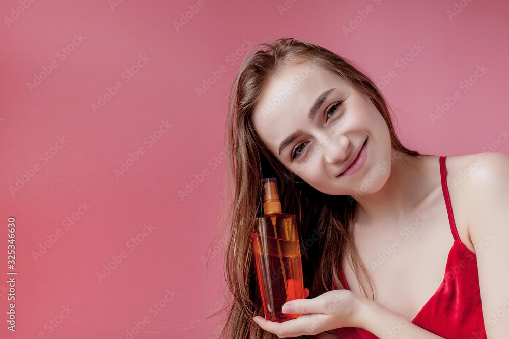 Smiling young woman applying oil mask to hair tips, haircare concept Smiling young woman applying oil mask to hair tips, haircare concept