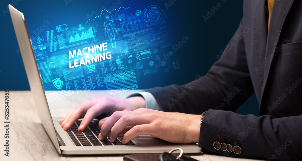 Businessman working on laptop with MACHINE LEARNING inscription, cyber technology concept Businessman working on laptop with MACHINE LEARNING inscription, cyber technology concept