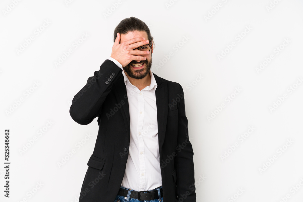 Young caucasian business man isolated on a white background blink at the camera through fingers, embarrassed covering face. Young caucasian business man isolated on a white background blink at the camera through fingers, embarrassed covering face.
