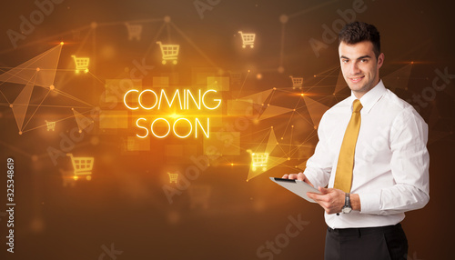 Businessman with shopping cart icons and COMING SOON inscription, online shopping concept
