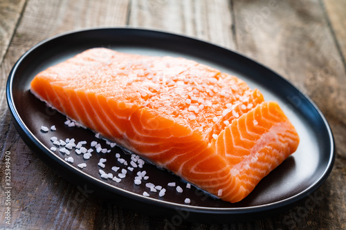 Fresh raw salmon steaks on wooden board