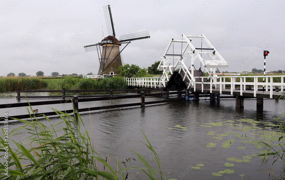 White drawbridge in front of mill in Kinderdijke, Netherlands