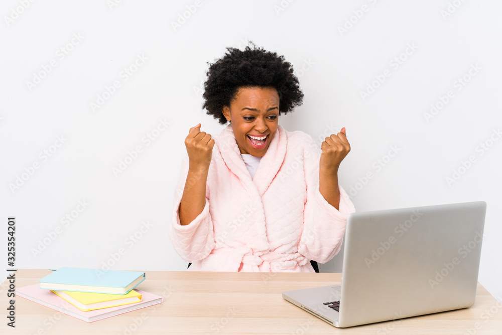 Middle aged african american woman working at home isolated cheering carefree and excited. Victory concept.