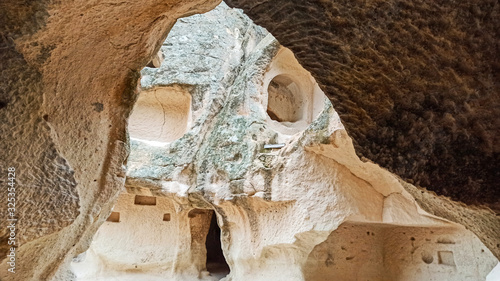 Volcanic rock landscape, stone cave houses at Zelve Valley in Cappadocia, Turkey photo