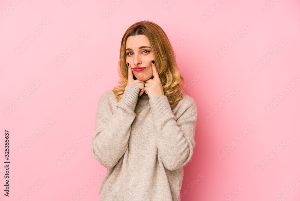 Young blonde cute woman wearing a sweater isolated doubting between two options. Young blonde cute woman wearing a sweater isolated doubting between two options.