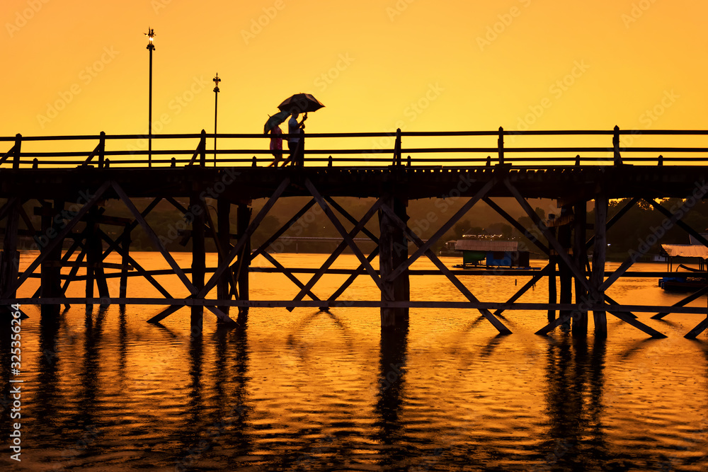 couple at mon wooden bridge at sunset