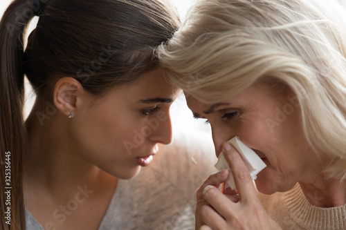 Millennial serious worried woman comforting crying mommy.