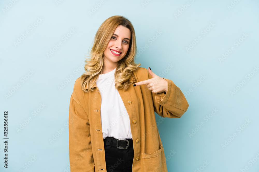 Young blonde pretty woman isolated person pointing by hand to a shirt copy space, proud and confident Young blonde pretty woman isolated person pointing by hand to a shirt copy space, proud and confident