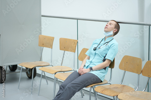 Tableau sur toile Exhausted caucasian female doctor sleeping at a work place after working overnig