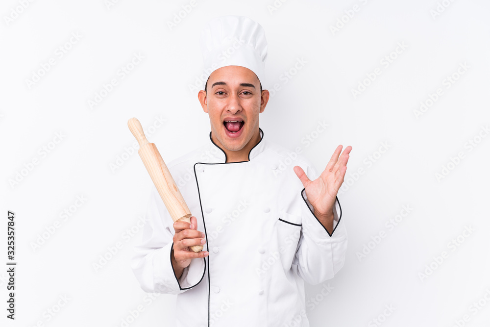 Young latin chef man isolated celebrating a victory or success Young latin chef man isolated celebrating a victory or success