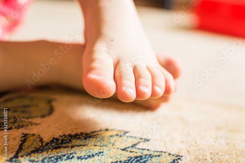 Small feet of child playing on the floor.