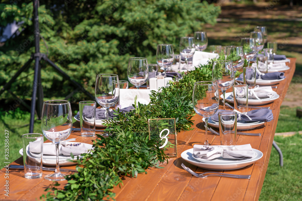 Preparing for an open-air party. Decorated with fresh flowers served tables. Table number. Decoration Details