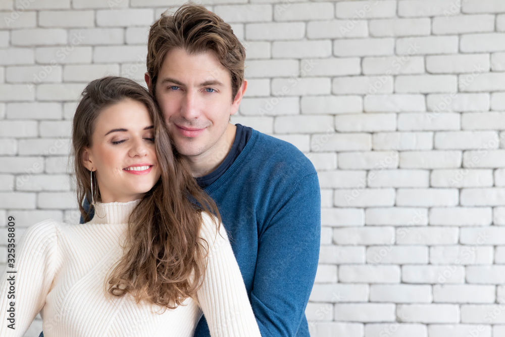 Caucasian couple hugging together.