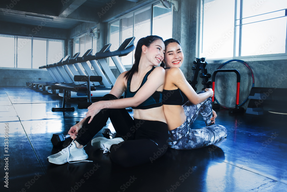 Two beautiful Asian women happy together at gym, warm up or cool down for workout. Exercise make people healthy, fit, reduce risk of disease and cancer. Cardio decrease stress and produce good hormone Two beautiful Asian women happy together at gym, warm up or cool down for workout. Exercise make people healthy, fit, reduce risk of disease and cancer. Cardio decrease stress and produce good hormone