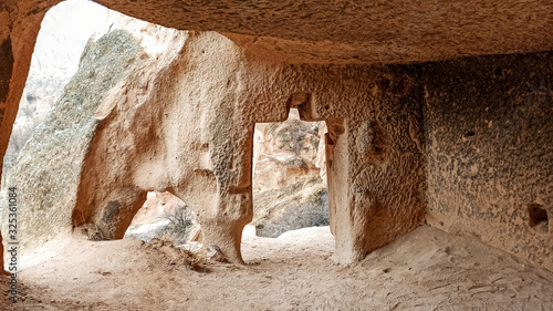 stone cave houses  and ancient monasteries with volcanic rock landscape at Zelve Valley in Cappadocia, Turkey photo