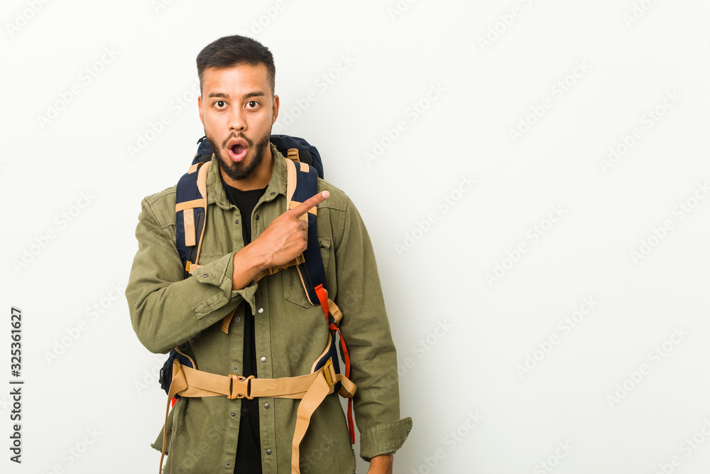 Young south-asian traveller pointing to the side Young south-asian traveller pointing to the side