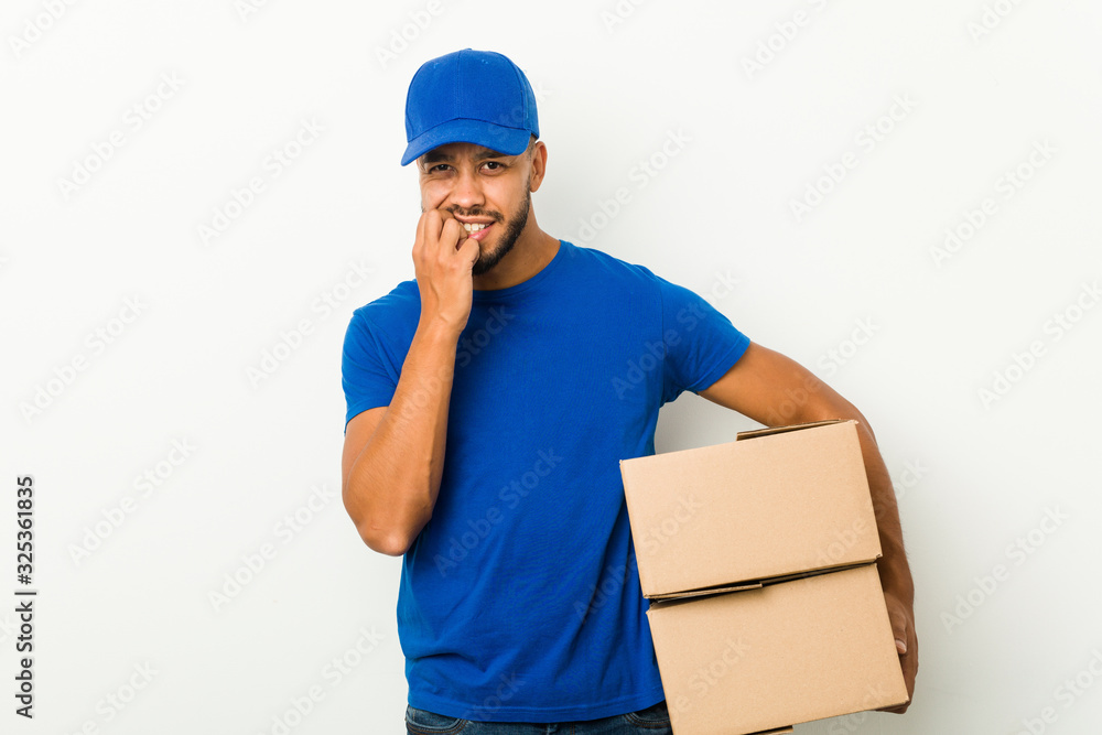 Young south-asian delivery man biting fingernails, nervous and very anxious. Young south-asian delivery man biting fingernails, nervous and very anxious.