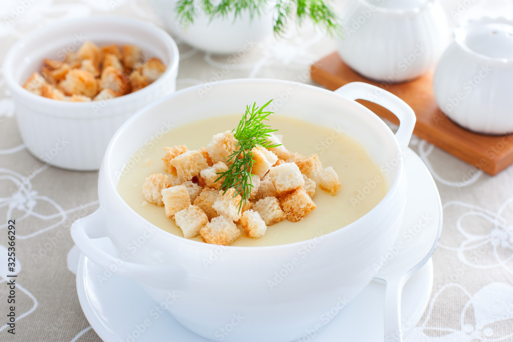 Mashed potato soup with homemade croutons in a white soup plate, horizontal Mashed potato soup with homemade croutons in a white soup plate, horizontal