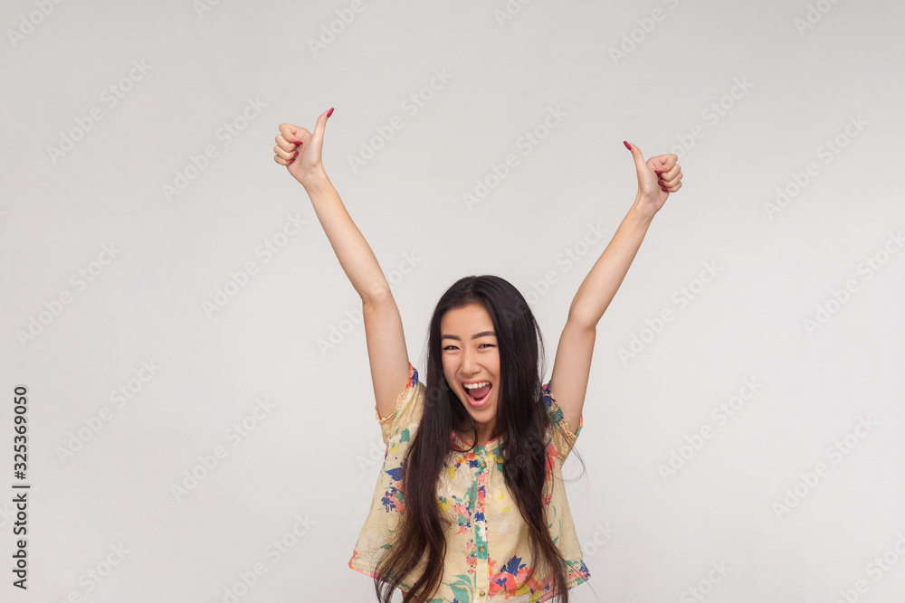 I did excellent job! Delighted pretty asian girl in summer blouse shouting in excitement, raising hands and showing thumbs up, emotionally reacting to victory, success. indoor studio shot isolated I did excellent job! Delighted pretty asian girl in summer blouse shouting in excitement, raising hands and showing thumbs up, emotionally reacting to victory, success. indoor studio shot isolated