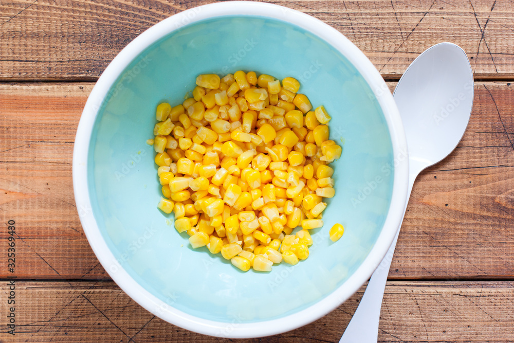 Step by step cooking salad with canned tuna and corn, step 2 - adding corn, top view, horizontal Step by step cooking salad with canned tuna and corn, step 2 - adding corn, top view, horizontal