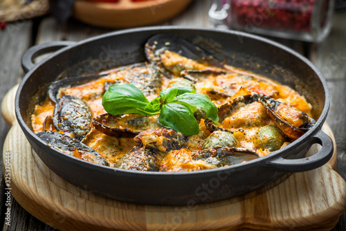 mussels with cheese sauce, in a frying pan