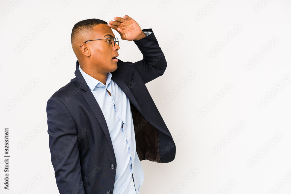 Young business latin man isolated on white background looking far away keeping hand on forehead. Young business latin man isolated on white background looking far away keeping hand on forehead.