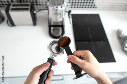 Guy prepare delicious aromatic coffee in a coffee machine. A simple way to make coffee