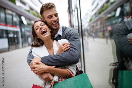 Happy couple with shopping bags. Sale, travel, love consumerism and people concept.