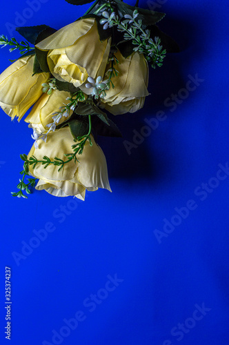 bouquet of yellow artificial flowers on a blue background