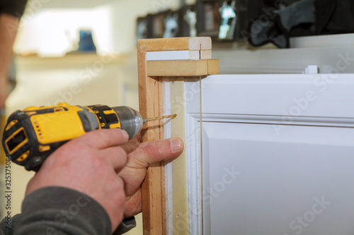 Master drills the cabinet door in the drilling a hole