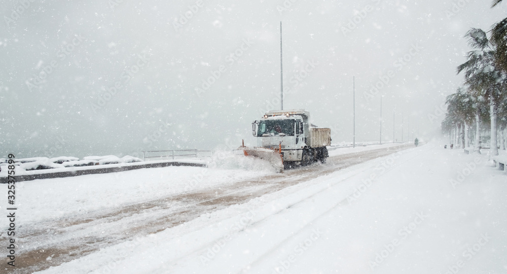 Truck cleaning winter road covered with snow Truck cleaning winter road covered with snow