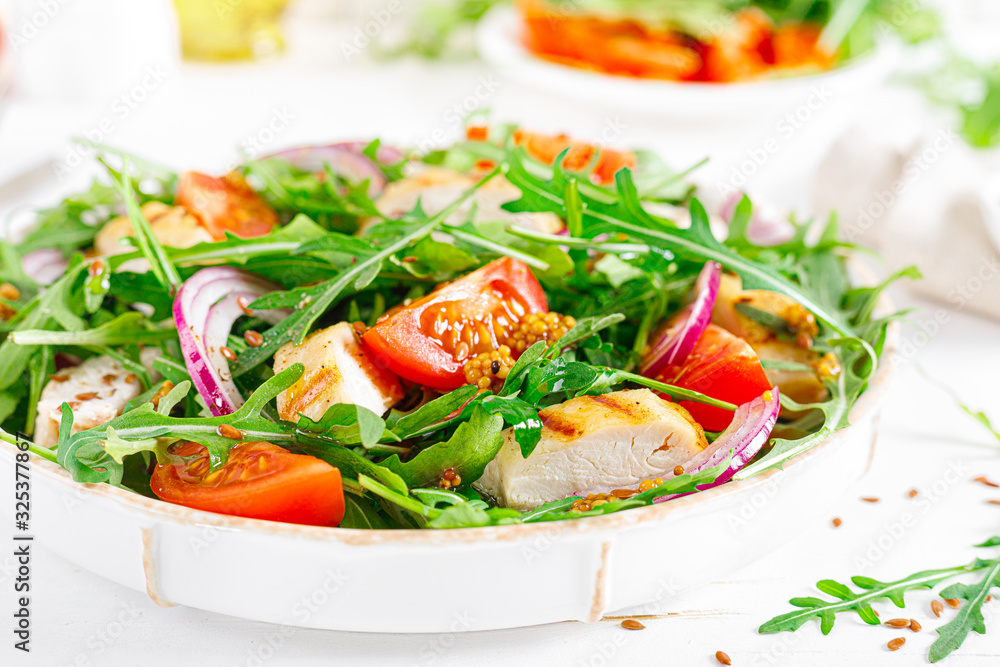 Fresh vegetable salad with grilled chicken fillet, breast, tomato and arugula