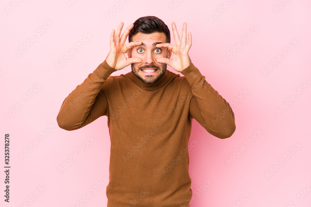 Young caucasian man against a pink background isolated keeping eyes opened to find a success opportunity. Young caucasian man against a pink background isolated keeping eyes opened to find a success opportunity.